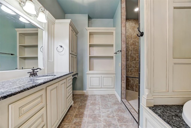 bathroom with vanity and tiled shower