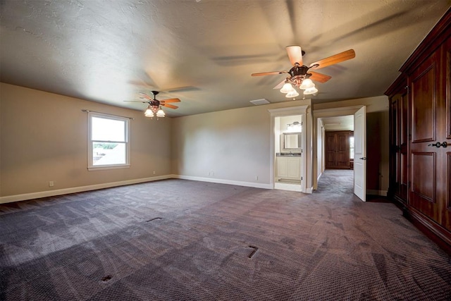 unfurnished room with dark colored carpet, ceiling fan, and a textured ceiling