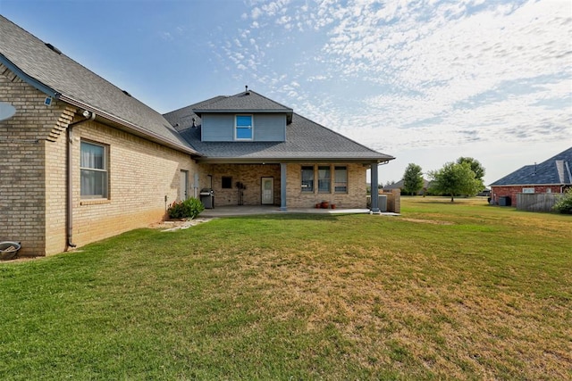 back of property with a yard and a patio