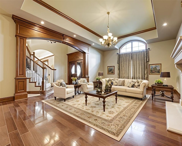 320 S Lysbeth Ct, Goldsby, OK 73093 - living room with a raised ceiling, arched walkways, ornamental molding, a chandelier, and stairway
