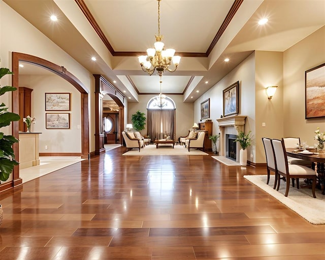 320 S Lysbeth Ct, Goldsby, OK 73093 - entrance foyer with a chandelier, arched walkways, a glass covered fireplace, wood finished floors, and recessed lighting