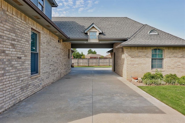 320 S Lysbeth Ct, Goldsby, OK 73093 - view of property exterior with brick siding, a shingled roof, and fence
