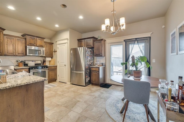 8609 SW 36th Ter, Oklahoma City, OK 73179 - kitchen featuring stainless steel appliances, tasteful backsplash, a chandelier, decorative light fixtures, and vaulted ceiling