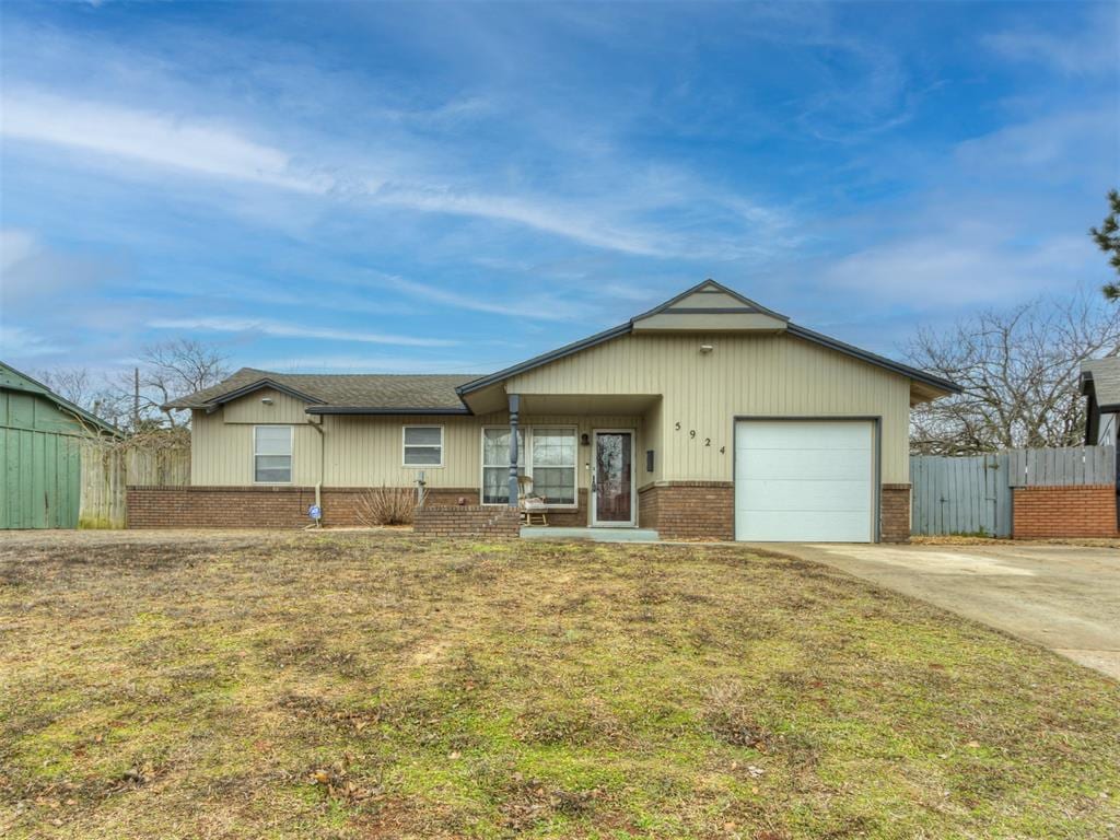 ranch-style house featuring a garage and a front lawn