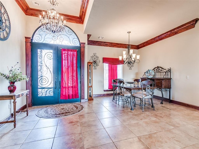 foyer entrance featuring crown molding, light tile patterned flooring, and a notable chandelier