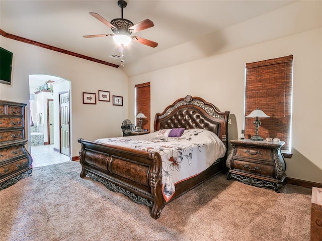 bedroom featuring ensuite bath, light colored carpet, vaulted ceiling, ornamental molding, and ceiling fan