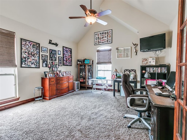 carpeted office space with ceiling fan and high vaulted ceiling