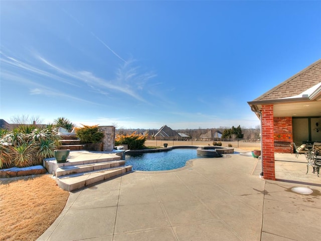 view of swimming pool with an in ground hot tub and a patio