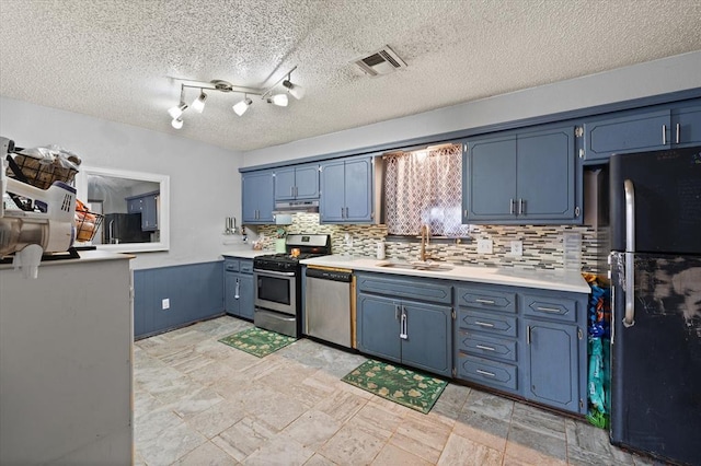 kitchen with blue cabinets, sink, a textured ceiling, appliances with stainless steel finishes, and decorative backsplash