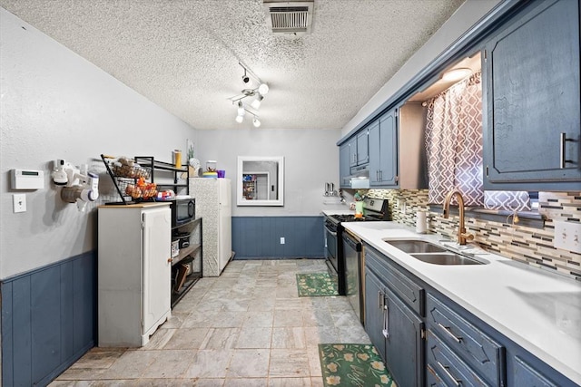 kitchen with sink, dishwasher, a textured ceiling, blue cabinets, and gas range