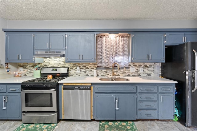 kitchen with sink, decorative backsplash, stainless steel appliances, and a textured ceiling