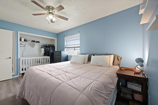 bedroom featuring ceiling fan, hardwood / wood-style floors, and a textured ceiling