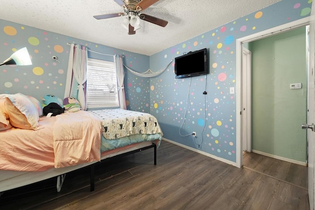 bedroom featuring dark hardwood / wood-style flooring, ceiling fan, and a textured ceiling