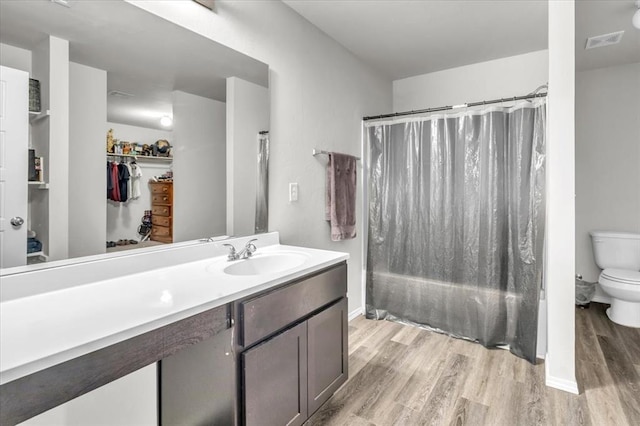 full bathroom featuring vanity, shower / tub combo, wood-type flooring, and toilet