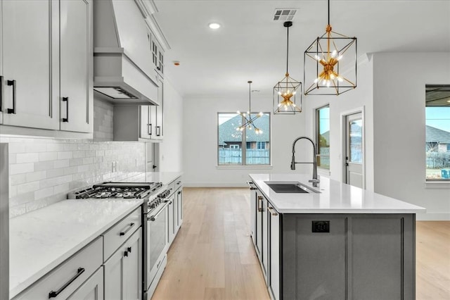 3305 Sugar Maple Way, Oklahoma City, OK 73179 - kitchen featuring high end stainless steel range oven, a chandelier, premium range hood, healthy amount of natural light, and recessed lighting