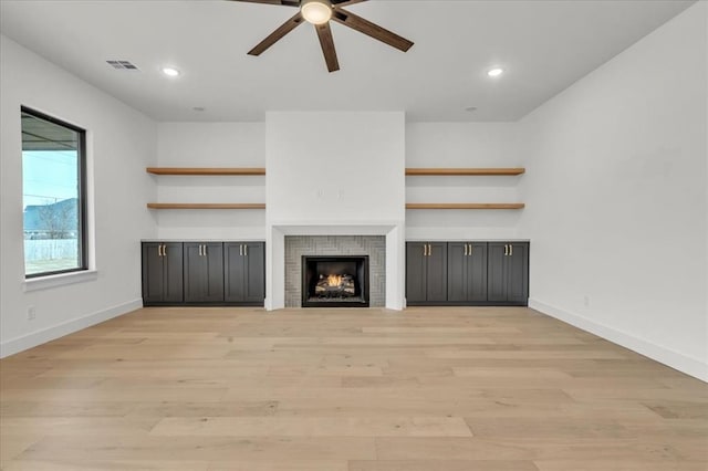 3305 Sugar Maple Way, Oklahoma City, OK 73179 - unfurnished living room featuring a ceiling fan, light wood-style floors, a warm lit fireplace, and recessed lighting