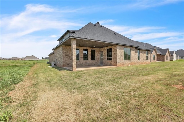 3305 Sugar Maple Way, Oklahoma City, OK 73179 - back of house featuring brick siding, a patio, a yard, and a shingled roof