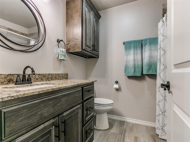 bathroom with vanity, toilet, and hardwood / wood-style floors