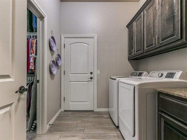 laundry room featuring separate washer and dryer and cabinets