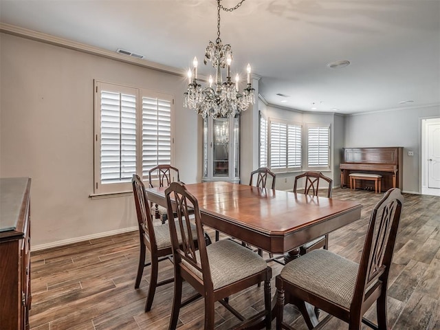 dining room with crown molding, dark wood-type flooring, and a notable chandelier