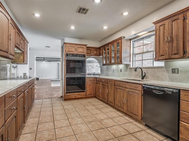 kitchen featuring sink, tasteful backsplash, light tile patterned floors, ceiling fan, and black appliances