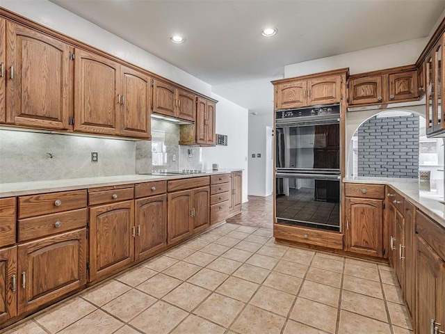 kitchen featuring light tile patterned floors, decorative backsplash, and black appliances