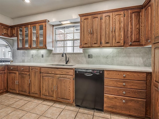 kitchen featuring sink, backsplash, dishwasher, and light tile patterned flooring