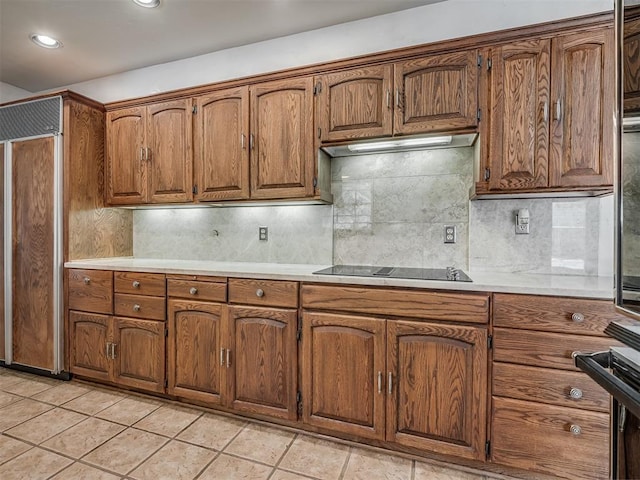 kitchen featuring light tile patterned floors, paneled built in refrigerator, black electric stovetop, oven, and decorative backsplash