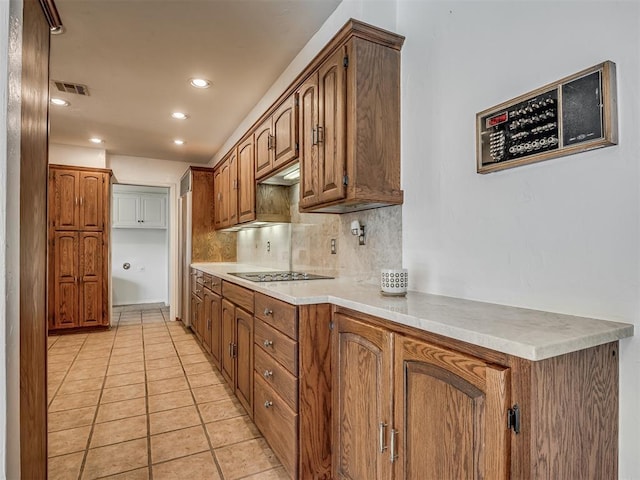 kitchen featuring black electric cooktop, tasteful backsplash, and light tile patterned floors