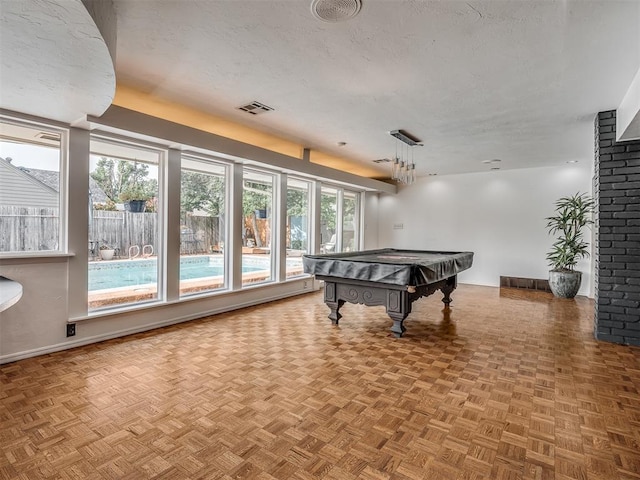 rec room with parquet floors, pool table, and a textured ceiling