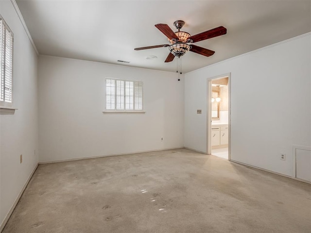 carpeted empty room with ornamental molding, plenty of natural light, and ceiling fan