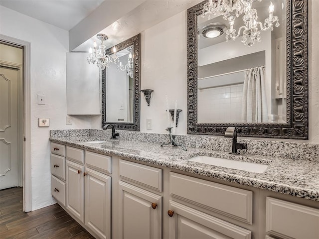 bathroom featuring an inviting chandelier, vanity, walk in shower, and hardwood / wood-style flooring