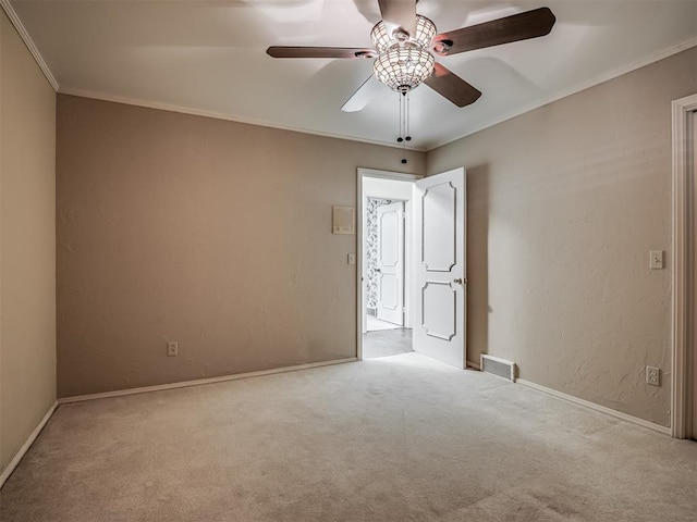 empty room featuring crown molding, light carpet, and ceiling fan