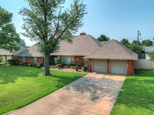 view of front facade featuring a garage, driveway, a chimney, a front lawn, and brick siding