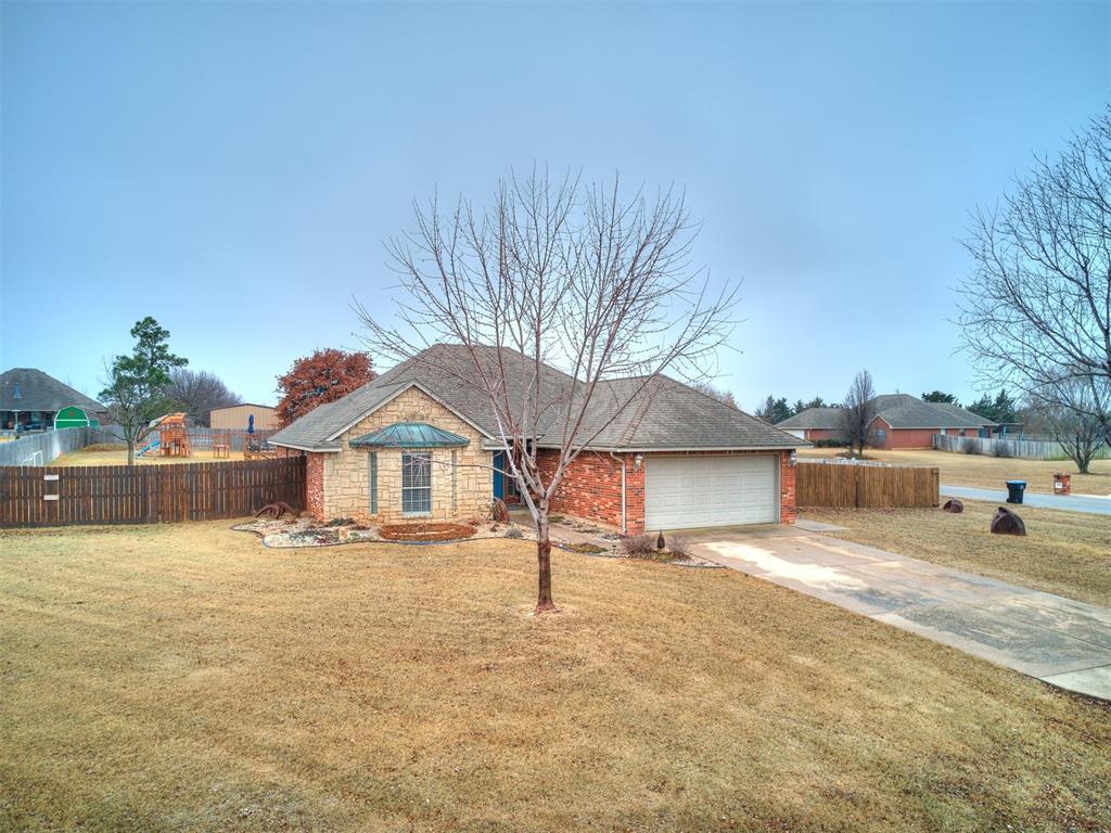 ranch-style home with a garage and a front lawn