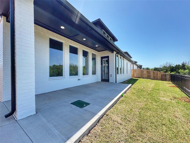 15521 Aparados Way, Edmond, OK 73013 - rear view of property with fence, a patio area, a lawn, and brick siding