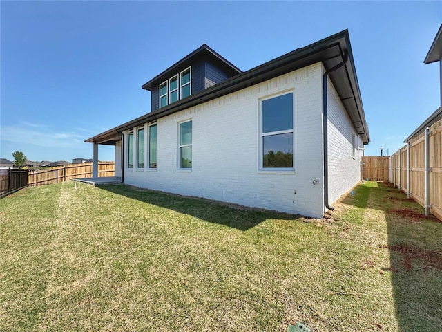 15521 Aparados Way, Edmond, OK 73013 - back of house featuring a lawn, brick siding, and a fenced backyard