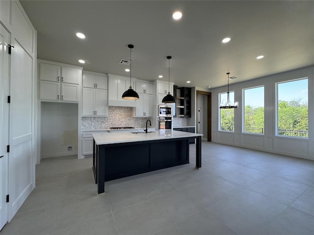 15521 Aparados Way, Edmond, OK 73013 - kitchen with light countertops, a sink, decorative backsplash, a chandelier, and white cabinetry