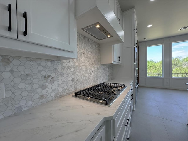 15521 Aparados Way, Edmond, OK 73013 - kitchen with stainless steel gas stovetop, ventilation hood, visible vents, and white cabinetry