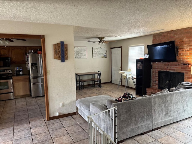 tiled living room featuring a brick fireplace, a textured ceiling, and ceiling fan