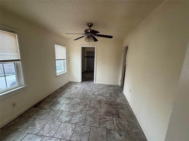 spare room with ceiling fan and a textured ceiling