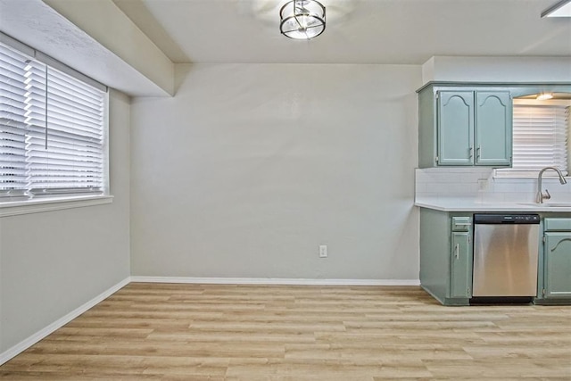 kitchen with sink, stainless steel dishwasher, light hardwood / wood-style floors, and green cabinetry