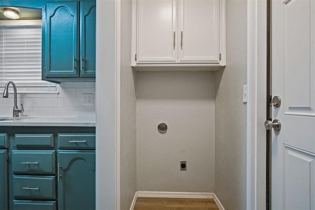 laundry area with hardwood / wood-style flooring, cabinets, hookup for an electric dryer, and sink