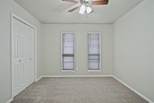 unfurnished bedroom with ceiling fan, a closet, and carpet