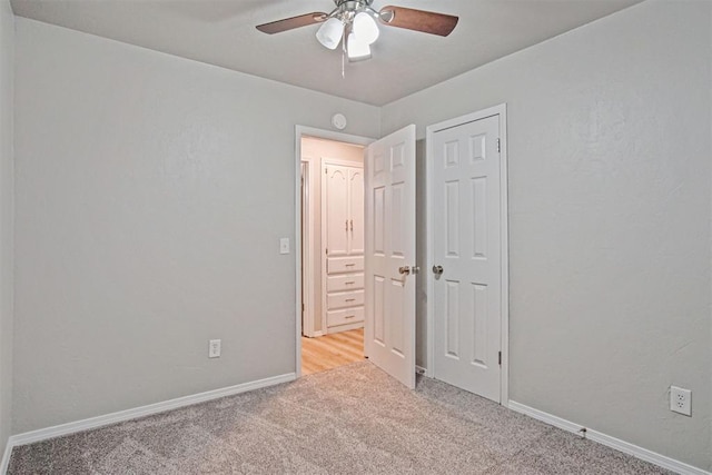 unfurnished bedroom with ceiling fan, a closet, and light carpet