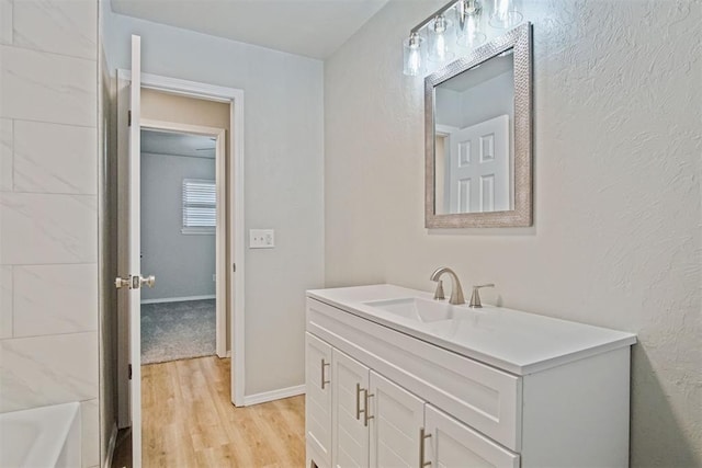 bathroom with vanity, hardwood / wood-style floors, and a bathtub