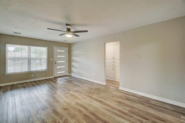 empty room featuring ceiling fan and light hardwood / wood-style floors