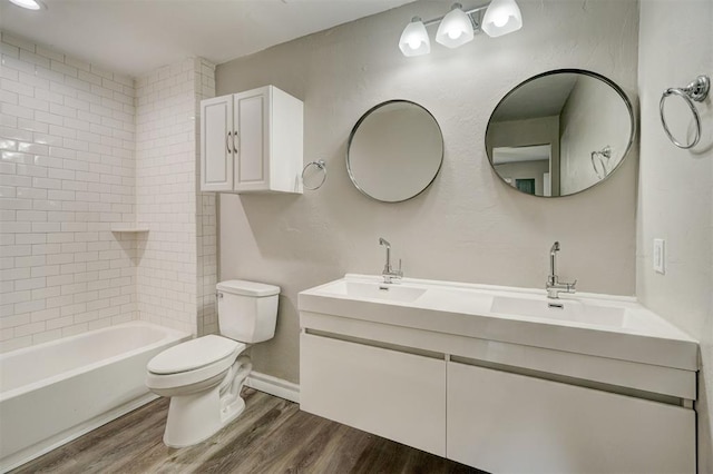 full bathroom with tiled shower / bath, wood-type flooring, toilet, and vanity