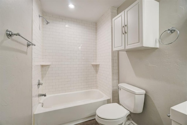 bathroom with tiled shower / bath and toilet