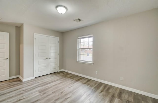 unfurnished bedroom featuring a closet and light hardwood / wood-style flooring